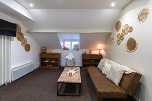 a living room with a couch and a table at Hôtel De La Plage in Courseulles-sur-Mer