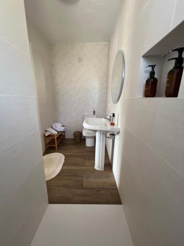 a white bathroom with a sink and a mirror at Villa tosalet in Jávea