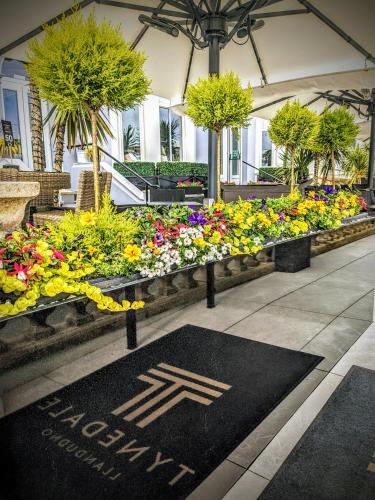 eine Darstellung von Blumen und Pflanzen in einem Gebäude in der Unterkunft Tynedale Hotel in Llandudno