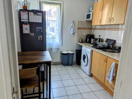 une cuisine avec un réfrigérateur noir et une machine à laver dans l'établissement Magnifique T1 bis à proximité de Paris, à Fontenay-aux-Roses