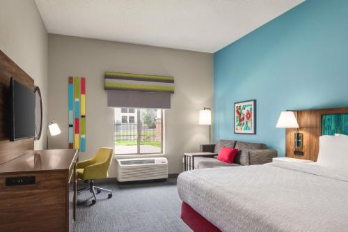 斯普林菲尔德Hampton Inn & Suites Springfield的酒店客房设有一间带一张床和一张书桌的卧室
