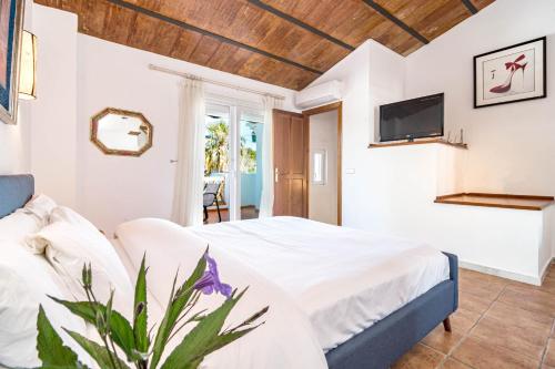a bedroom with a bed and a tv on the wall at PG9 - Andalucian 3-story townhouse near Estepona in Estepona