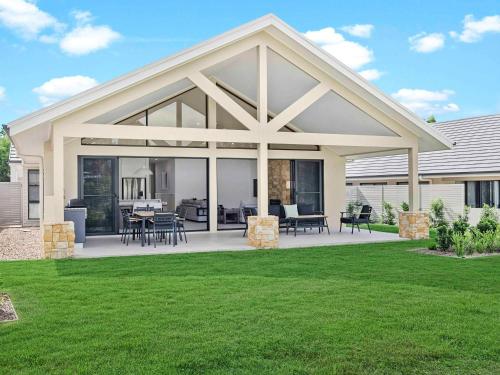 a house with a large screened in patio with grass at Peppers Hunter Valley - formerly Grand Mercure in Pokolbin