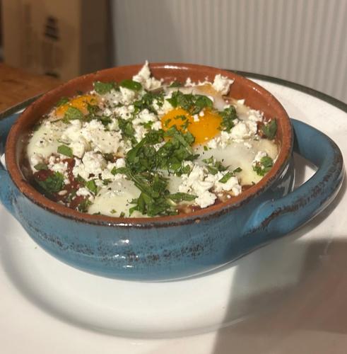a bowl of food with an egg on a plate at Gracie's Lodge at Woody's Glamping in Llangernyw
