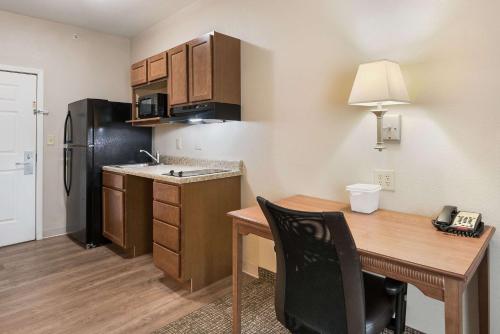 a small kitchen with a desk and a refrigerator at Suburban Studios Waterloo in Waterloo