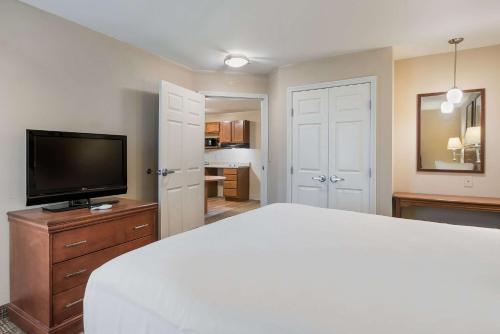 a bedroom with a bed and a flat screen tv at Suburban Studios Waterloo in Waterloo