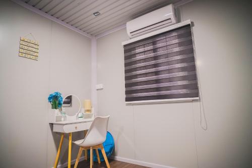 a room with a desk and two chairs and a window at Redang Bro Roomstay in Kuala Terengganu