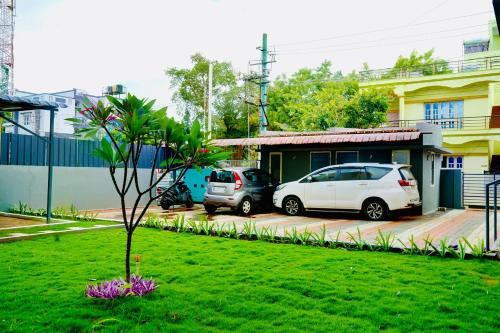 two cars parked in a yard next to a house at Elite Enclave - Mysore - 2BHK Luxury Serviced Apartments in Mysore