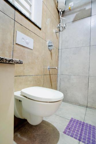 a bathroom with a white toilet and a shower at Elite Enclave - Mysore - 2BHK Luxury Serviced Apartments in Mysore