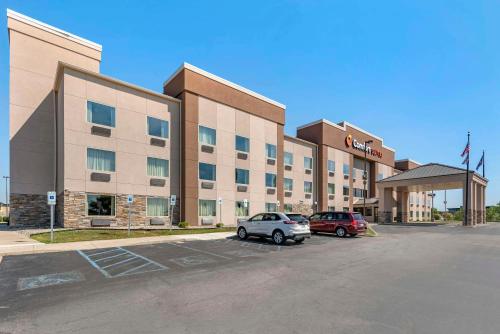 a hotel with two cars parked in a parking lot at Comfort Suites Fort Wayne - Southwest in Fort Wayne