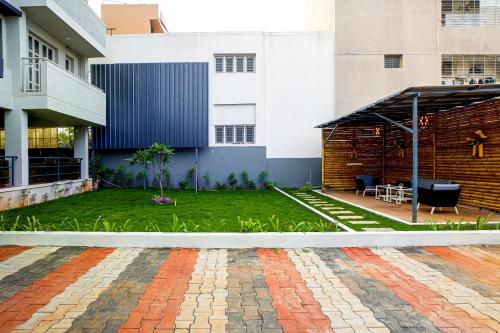 a courtyard of a building with a grass yard at Elite Enclave - Mysore - 2BHK Luxury Serviced Apartments in Mysore