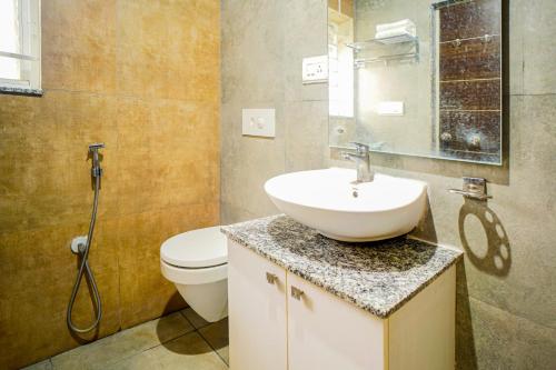 a bathroom with a sink and a toilet at Elite Enclave - Mysore - 2BHK Luxury Serviced Apartments in Mysore