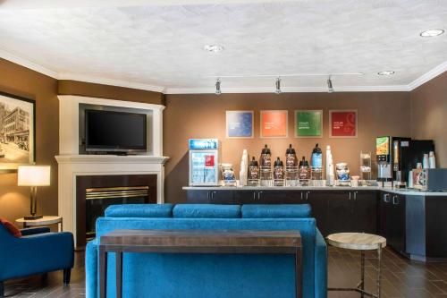 a bar with a blue couch and a television at Comfort Suites Scranton near Montage Mountain in Scranton