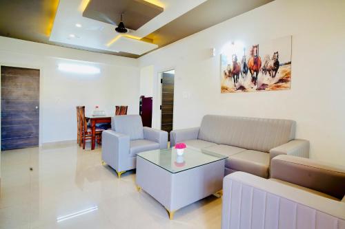 a living room with a couch and a table at Elite Enclave - Mysore - 2BHK Luxury Serviced Apartments in Mysore
