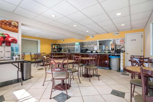 a restaurant with tables and chairs and a counter at Quality Inn Little Creek in Virginia Beach