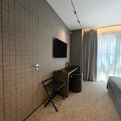 a bedroom with a desk and a television on a wall at Zeta Rentals in Bari