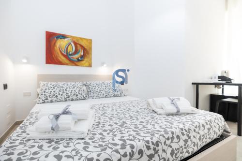 a bedroom with a bed with a black and white comforter at Al Posto Giusto - Self Check in in Cefalù