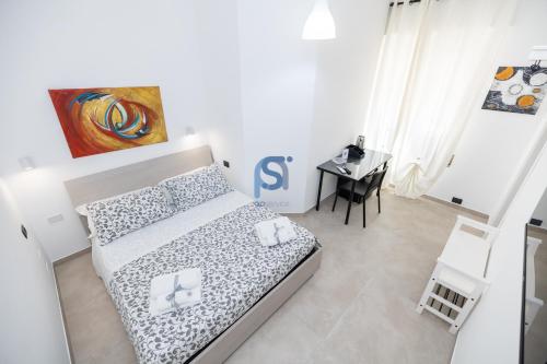 a small bedroom with a bed and a desk at Al Posto Giusto - Self Check in in Cefalù