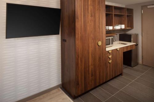 a room with a kitchen with a microwave and a door at Home2 Suites By Hilton New York Times Square in New York