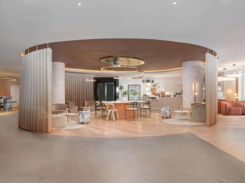 a lobby with a table and chairs and a kitchen at Mercure London Earls Court in London