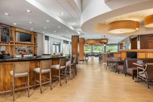 a bar in a restaurant with tables and chairs at Doubletree By Hilton Greensboro Airport in Greensboro