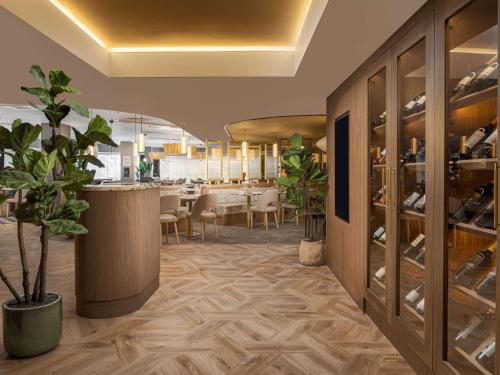 a dining room with a table and a wine cellar at Mercure London Earls Court in London
