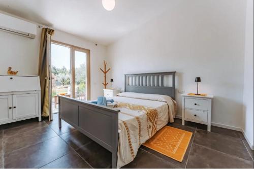 een slaapkamer met een bed en een groot raam bij Tenuta Naturale in Villa San Pietro