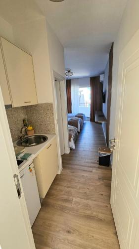 a small kitchen with a sink and a living room at Villa Alba Apartments in Dobra Voda