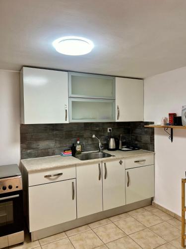 a kitchen with white cabinets and a sink at Melambai in Eilat