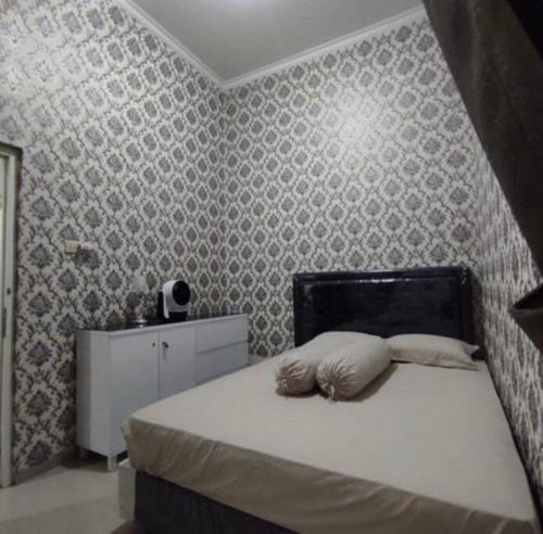 a bedroom with a bed and a wall at Villa Batu Permata Garden in Malang