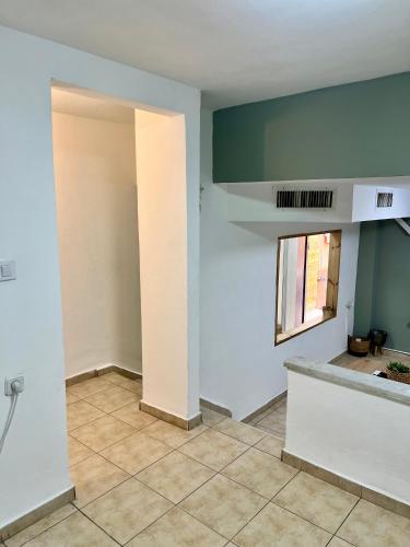 an empty room with white walls and a window at Melambai in Eilat