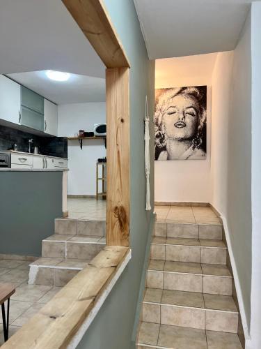 a staircase in a kitchen with a painting on the wall at Melambai in Eilat