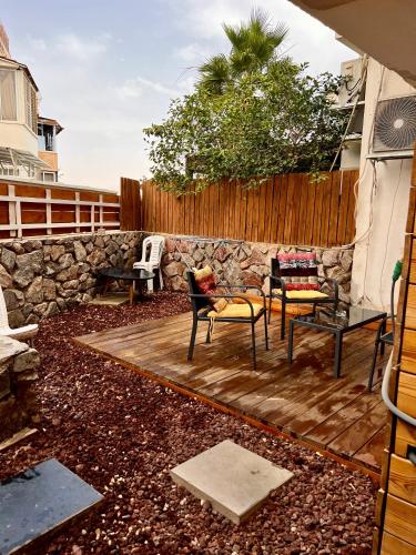 a patio with chairs and a stone wall at Melambai in Eilat