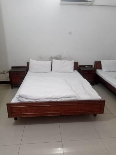 a bed with white sheets and pillows in a room at Hotel AL-Habib Islamabad in Islamabad