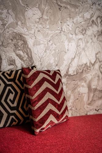 a pillow sitting on a bed next to a wall at Apartments Aois 4 Elements Suites in La Valle