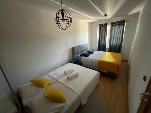 une petite chambre avec deux lits et un lustre dans l'établissement New Formula, à Sarajevo