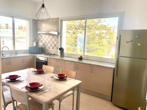 a kitchen with a table and a refrigerator at Appartement haut standing à Menzeh5 in Ariana