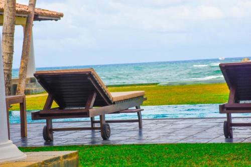 two lounge chairs sitting next to the ocean at Villa Olu in Galle