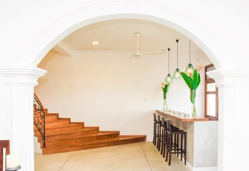 a dining room with stairs and a table with chairs at Villa Olu in Galle