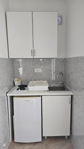 a kitchen with white cabinets and a sink at Villa Alba Apartments in Dobra Voda