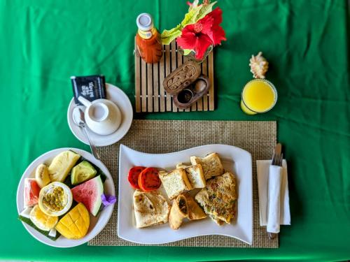 キジカジにあるLala Land Lodgeの2枚の皿に盛られた食べ物とコーヒーカップが置かれたテーブル