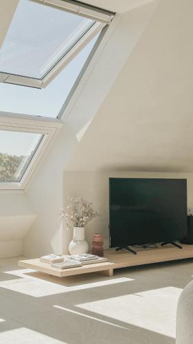 Una sala de estar con un televisor de pantalla plana en un techo. en CODAK suite, en Kluisbergen