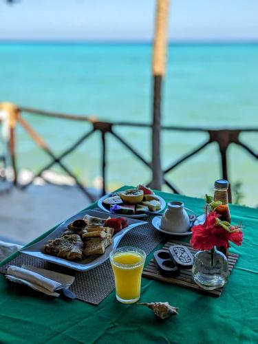 キジカジにあるLala Land Lodgeの食べ物と飲み物を一皿用意したテーブル