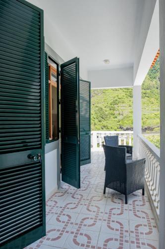 a patio with black doors and a table and chairs at São Vicente Guest House in São Vicente