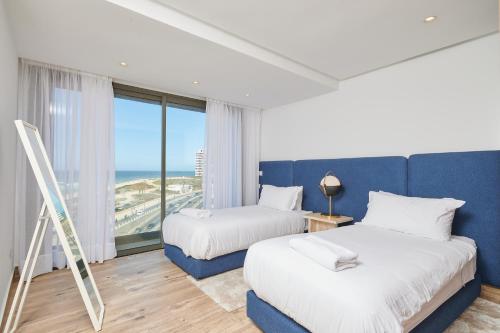 deux lits dans une chambre avec vue sur l'océan dans l'établissement TheCasaEdition - Bel Azur - Sea View & Hassan II Mosqué Residency, à Casablanca