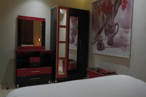 a bedroom with a bed and a dresser and a mirror at دار السلام للشقق المخدومة الجوف دومة الجندل in Dawmat al Jandal