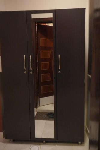 a black cabinet with a mirror in a room at دار السلام للشقق المخدومة الجوف دومة الجندل in Dawmat al Jandal