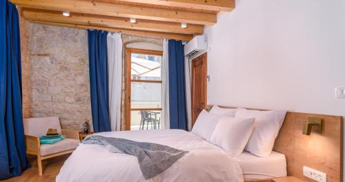 a bedroom with a bed with blue curtains and a window at Oleander Trogir Suites in Trogir