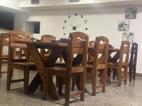 a wooden dining room table and chairs with a clock on the wall at Hotel Tigran Mets Yerevan in Yerevan