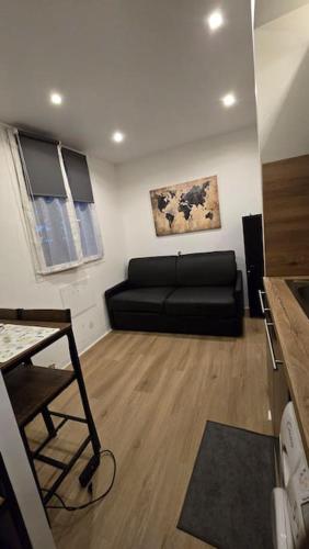 un salon avec un canapé noir dans une pièce dans l'établissement Studio Meublé Toulon, à Toulon